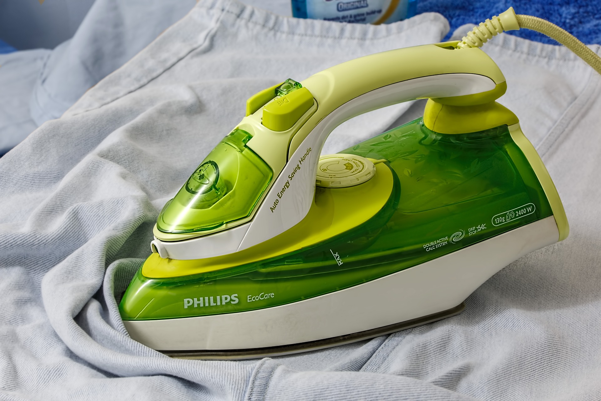 Philips EcoCare iron on folded clothing, illustrating light housekeeping services for seniors, including laundry assistance and maintaining a tidy home environment.